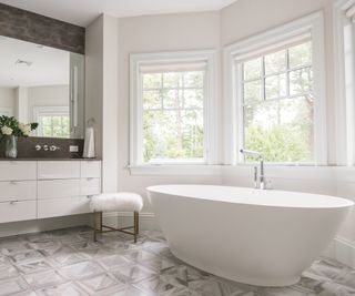 Spacious bathroom with a vanity separating the bath and walk-in shower