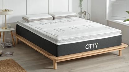 Otty cooling mattress topper on bed with branding