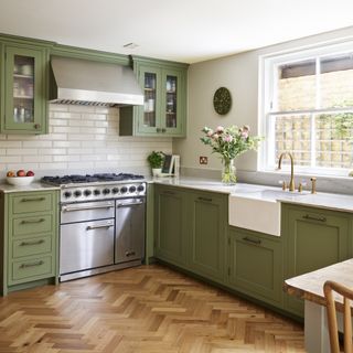 kitchen with green cabinet, white tiles, wooden flooring