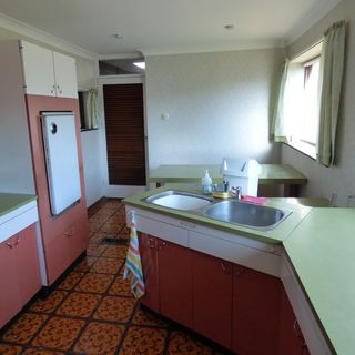 warp kitchen with patterned floor tiles and pink formica cabinets