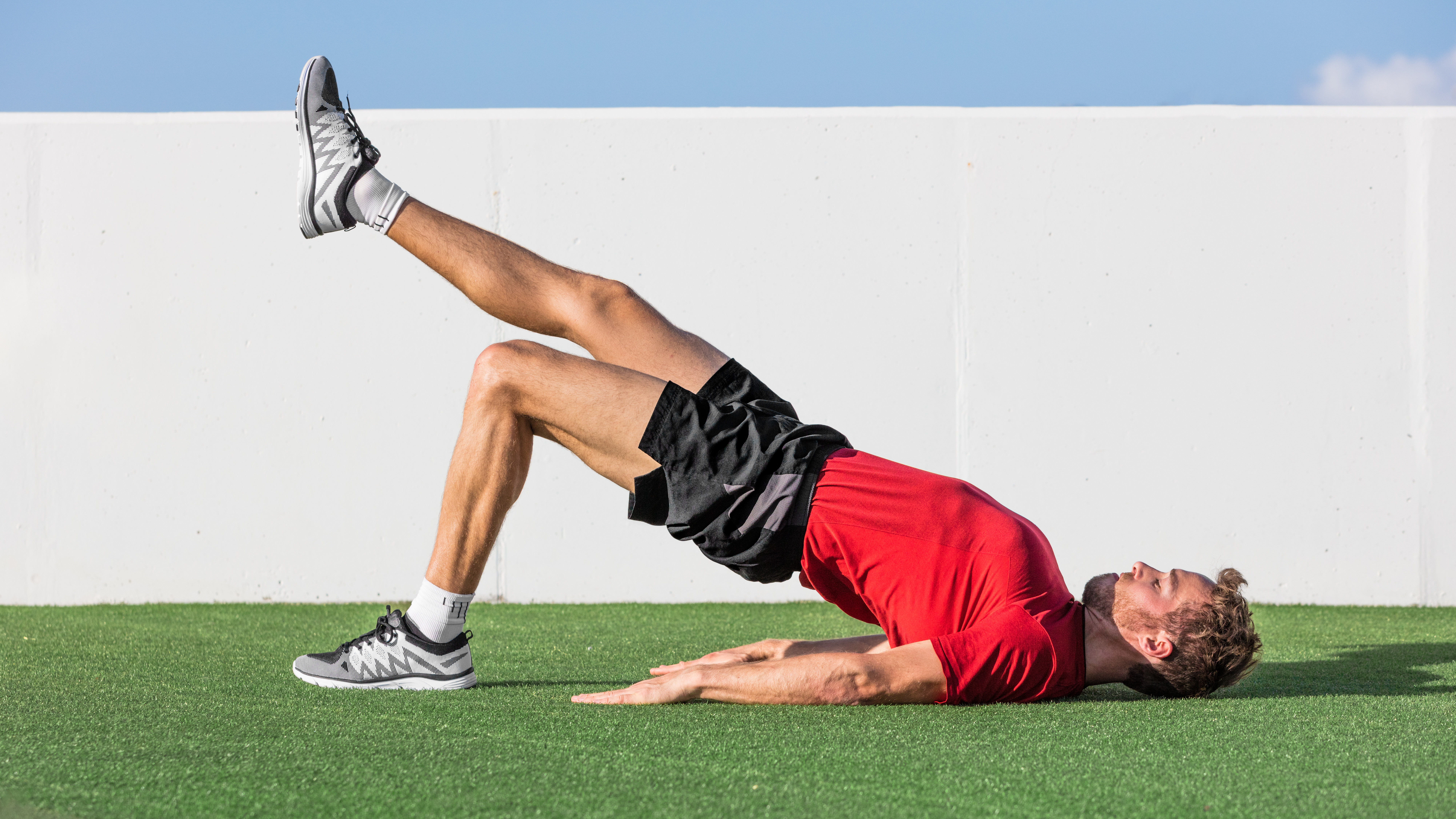 Man doing glute bridges outside