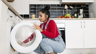 Woman putting laundry into a washing machine