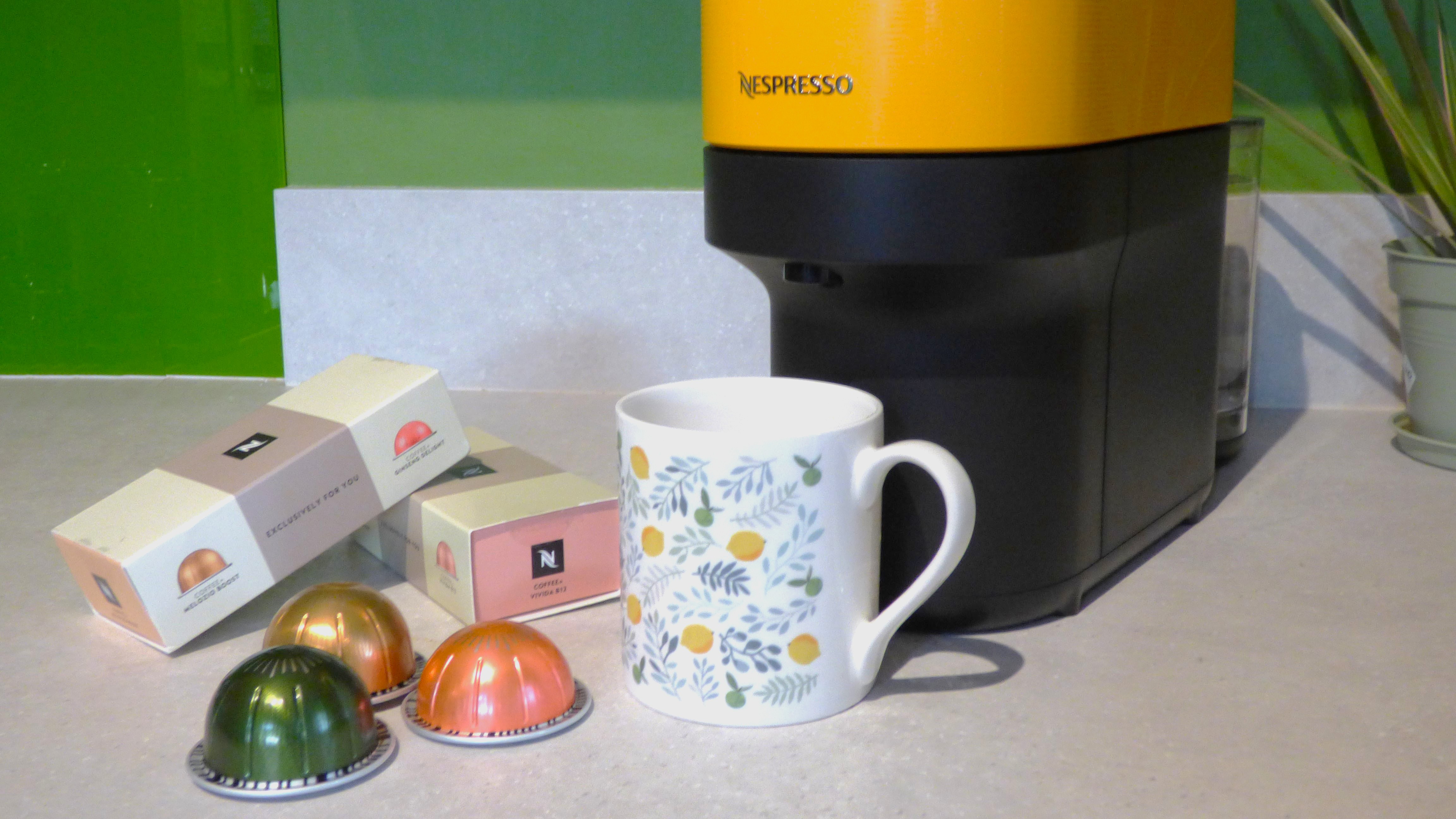 Nespresso Vertuo+ machine with Coffee+ capsules and mug on kitchen counter