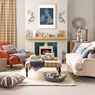 Neutral living room with cream wood burning stove by patterned ottoman