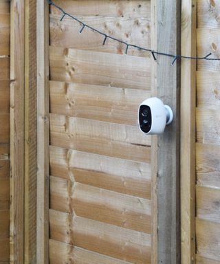 Outdoor security camera mounted on a fence