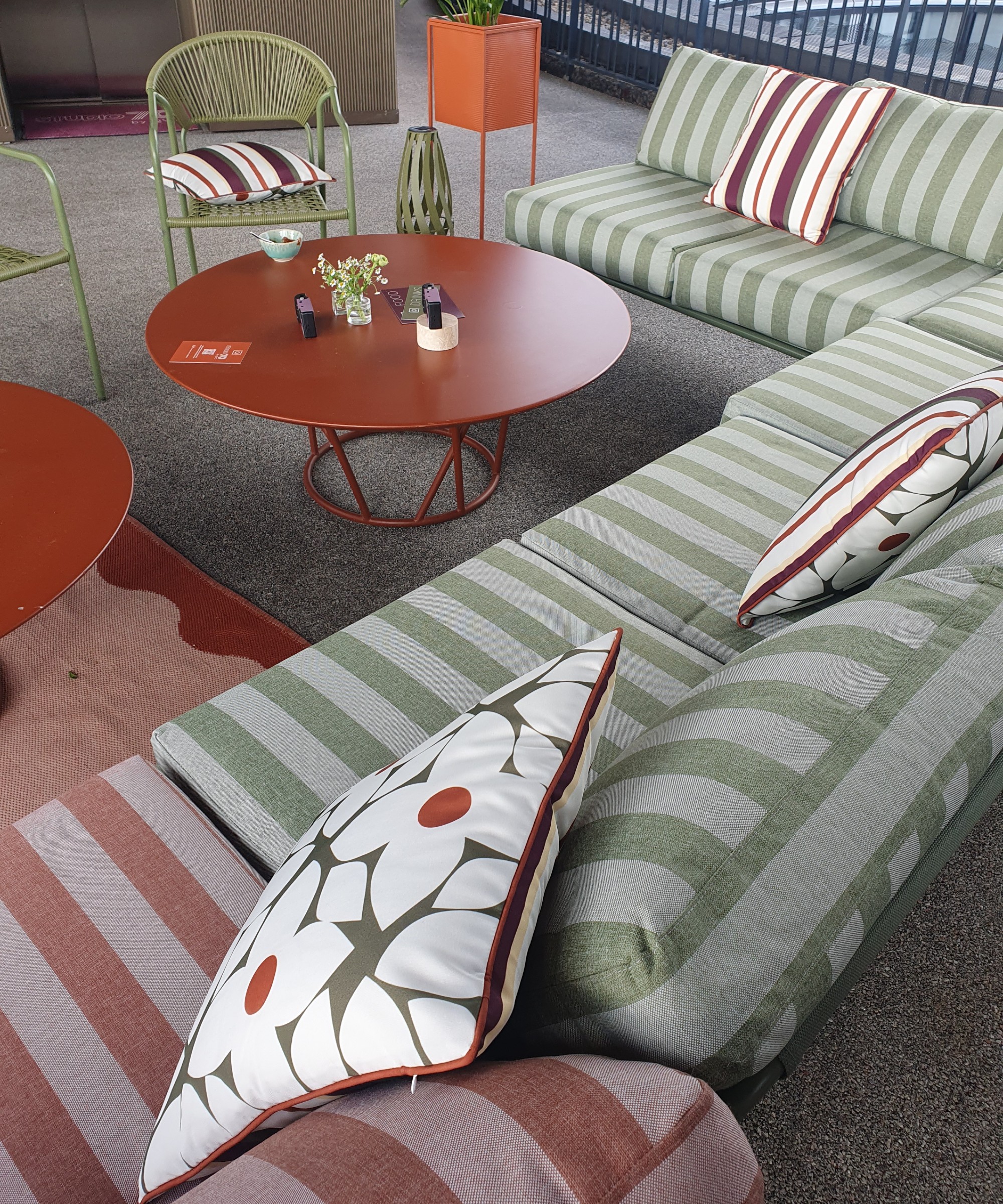 Two-seater outdoor sofas from QVC's Studio 70 garden collection in green and pinkstripes arranged into a large corner configuration