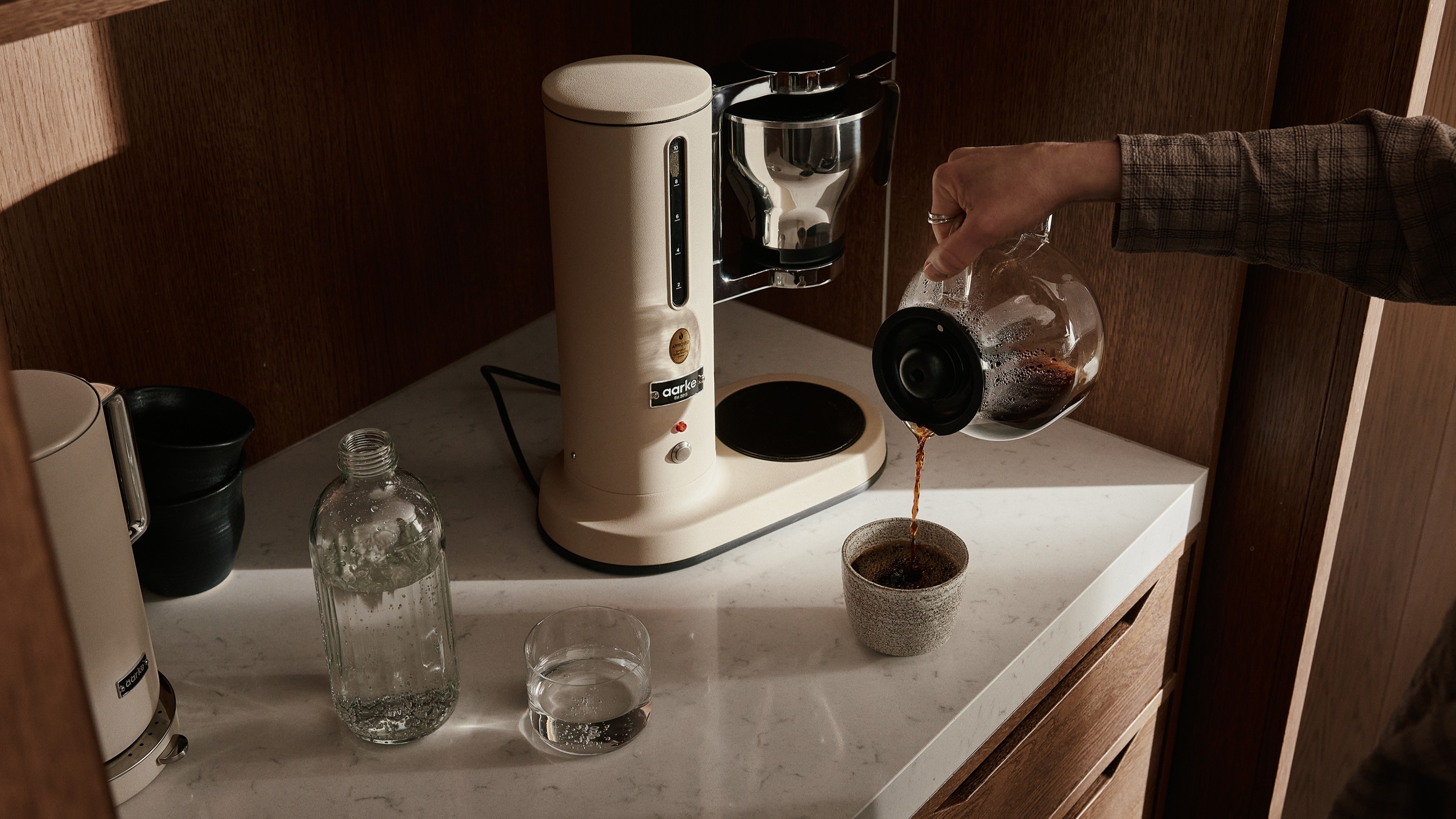 Aarke Coffee Maker in Sand on kitchen counter