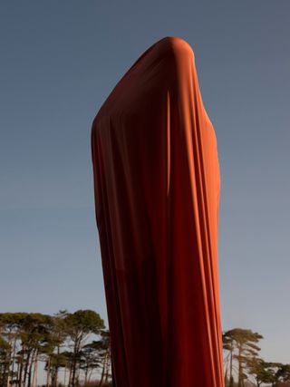 A person wrapped in orange fabric.