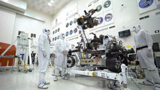 Engineers decked out in protective "bunny suits" inspect the Perseverance rover in a clean room in 2019, before the spacecraft launched to Mars.