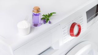 Essential oil next to detergent on top of washing machine