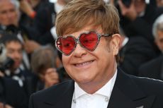 A headshot of Elton John wearing love-heart shaped glasses