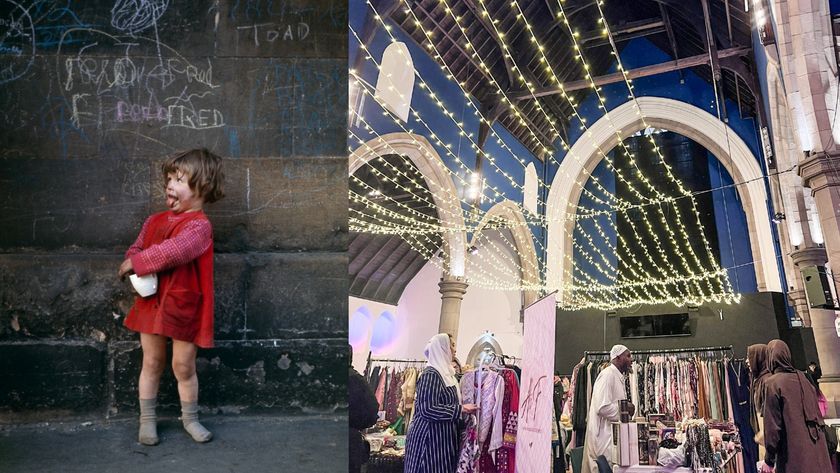 A composite image features two distinct scenes side-by-side: On the left, a small child, wearing a red dress and grey socks and shoes, stands against a dark wall covered in white chalk graffiti (including the word &quot;TOAD&quot; and &quot;FRED&quot;). The child is looking to the left with their mouth open and tongue slightly out, holding a small white object. On the right, the interior of a large hall, decorated with warm white string lights draped across the high, exposed wooden ceiling and large white stone arches, hosts a clothing bazaar with vendors and people browsing racks of clothes.
