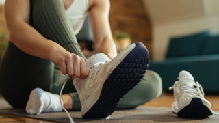 Woman lacing up her trainers for exercise