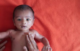 Baby having his chest stroked