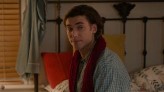 Dustin Milligan as Jack sitting on a bed in Hot Frosty. 