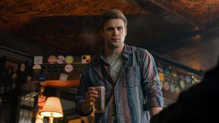 Leo Woodard holds a beer while stood in a pub