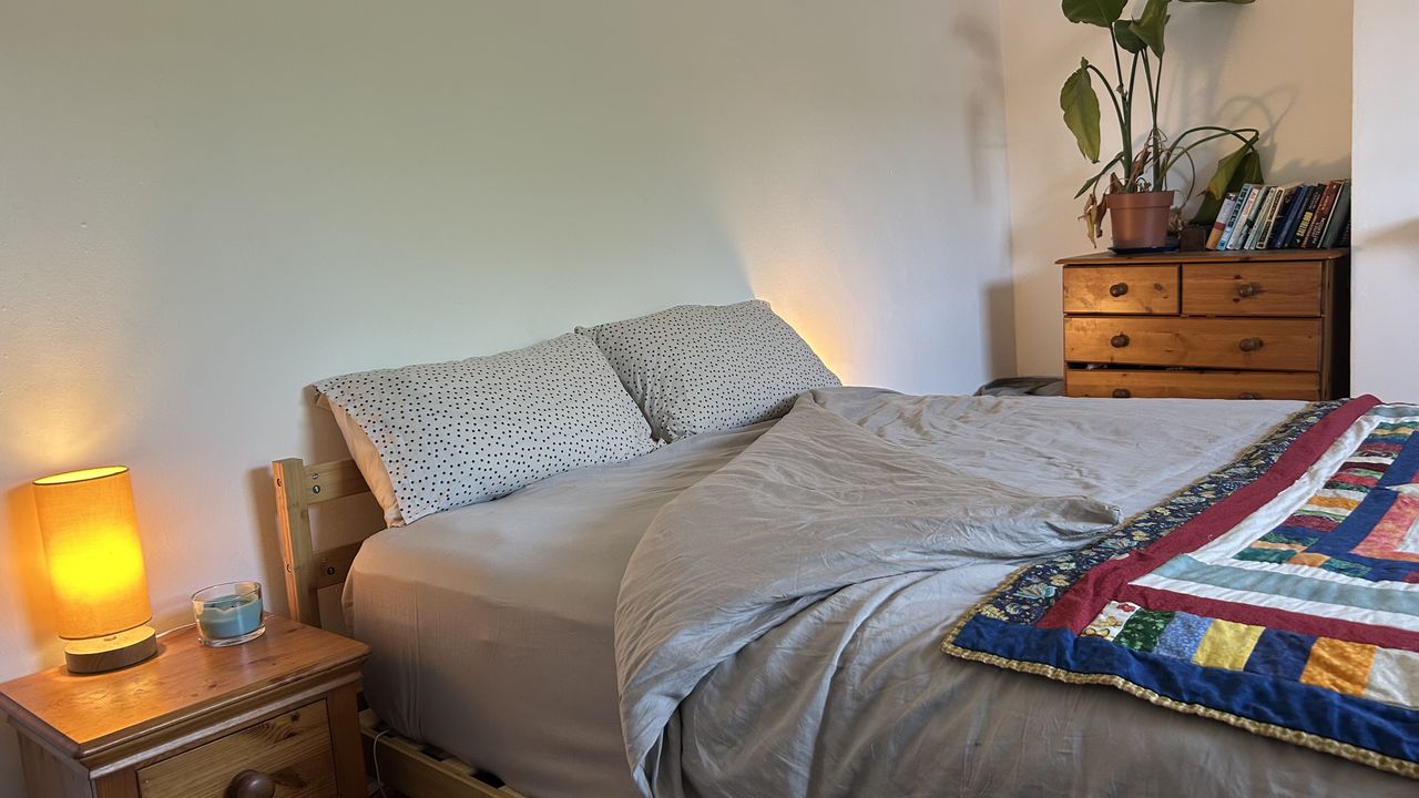 The DreamCloud Luxe Memory Foam mattress dressed in grey bedding with a colorful throw.