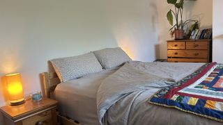 The DreamCloud Luxe Memory Foam mattress dressed in grey bedding with a colorful throw.