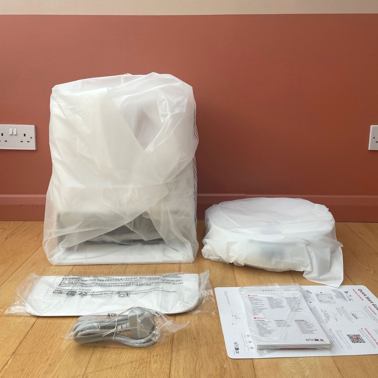 Roborock Qrevo Edge 2 Flow Robot Vacuum components wrapped in plastic and laid out on wooden floor