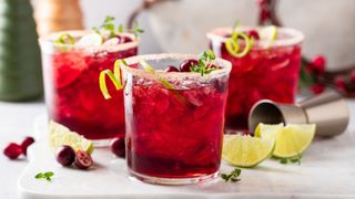 Cranberry fizz in three glasses with lime wedges