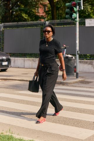 Nikki Ogunnaike wearing a black T-shirt, black pants, and cap-toe ballet flats.