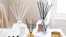 Two large reed diffusers next to a small reed diffusers on top of a kitchen counter
