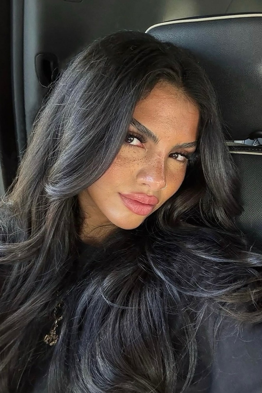 A model shows off her long butterfly haircut after applying clip-in extensions.