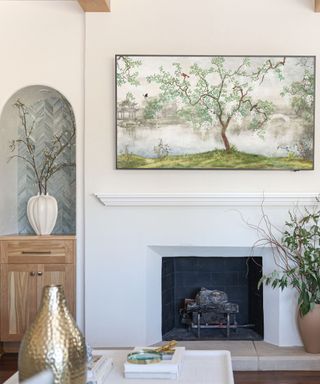 A white living room with a fireplace and arched cabinet alcove