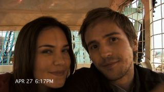 Odette Annable and Michael Stahl-David smiling on a ferris wheel.