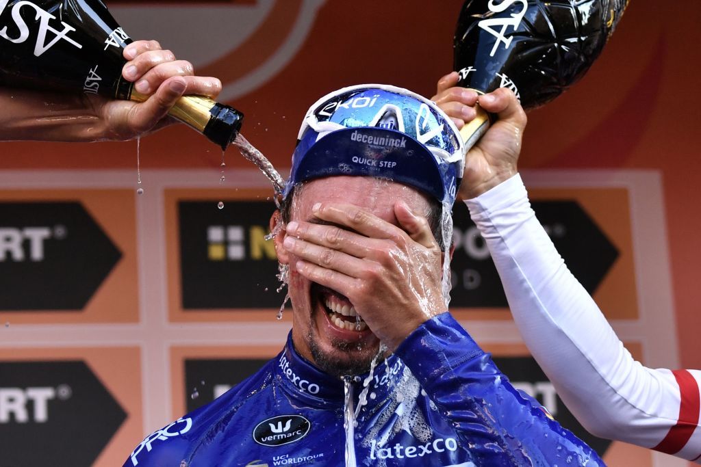 Michal Kwiatkowski and Oliver Naesen dump their champagne on Julian Alaphilppe