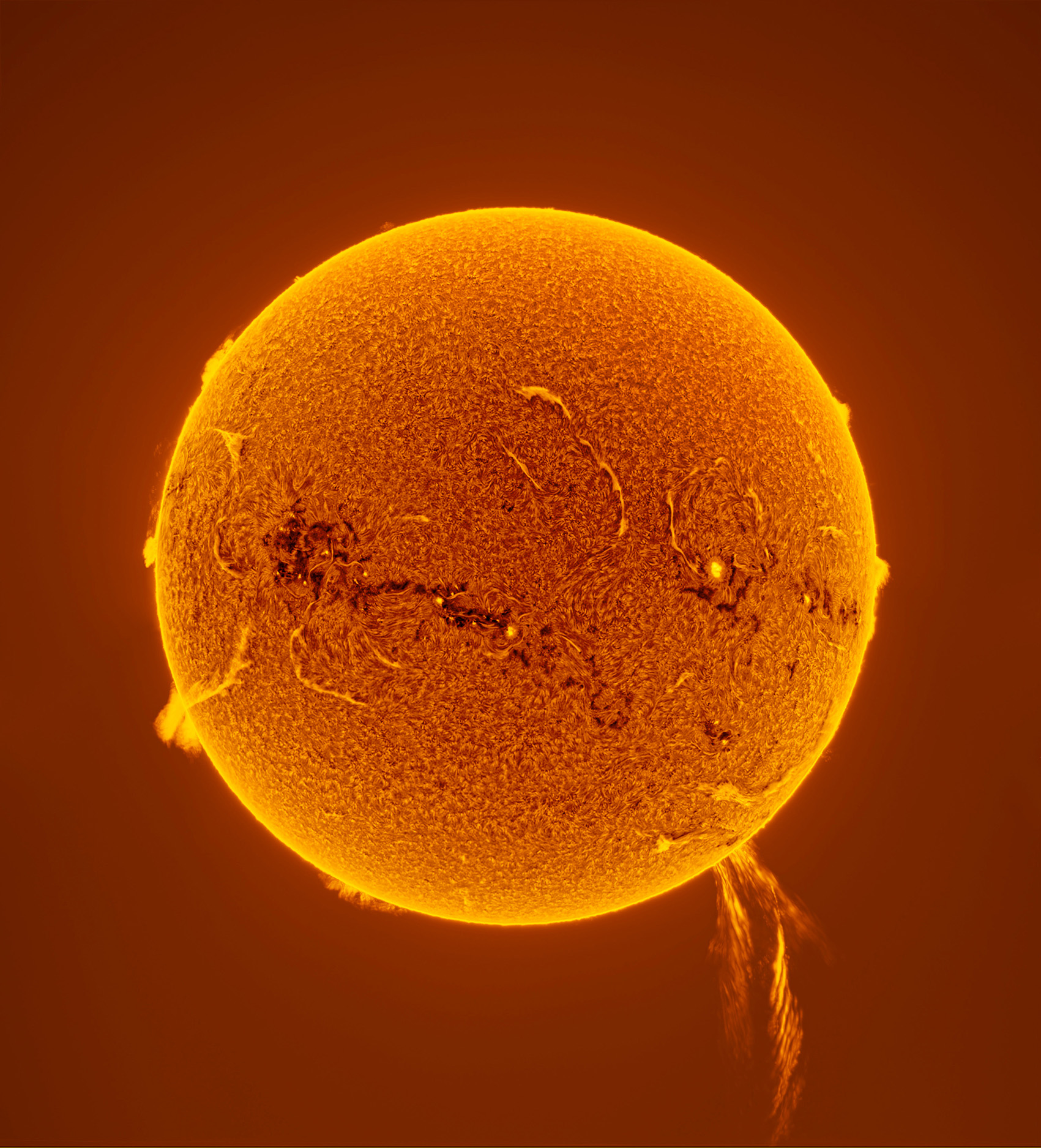 A vibrant, close-up view of the sun, showcasing its fiery surface texture and solar flares against a warm orange background