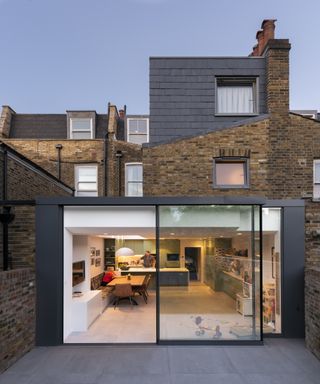 Exterior shot of Victorian terrace with lit dining room