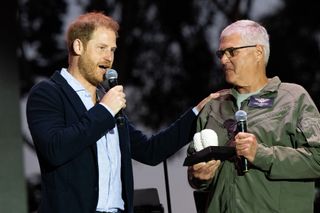 Prince Harry , Duke of Sussex (L) presents an award to Santa Barbara County Air Support Pilot Loren Courtney during the One805Live Fall Concert on September 20, 2024 in Carpinteria, California.