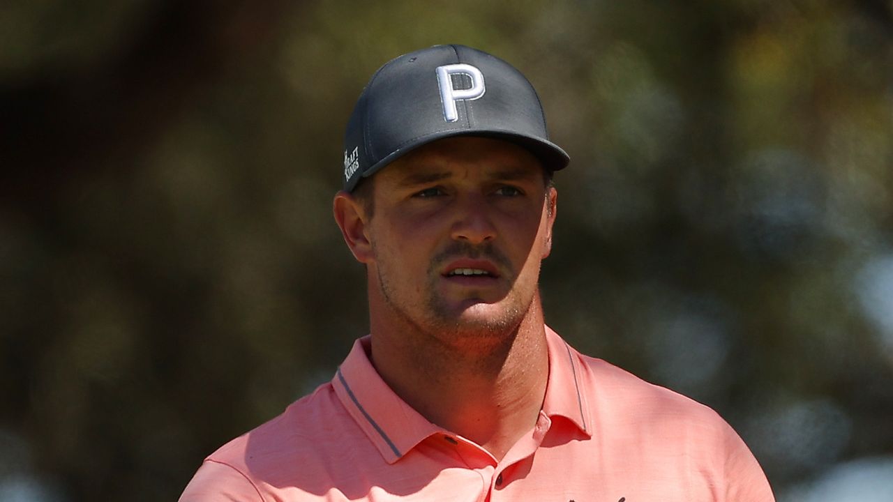 Bryson DeChambeau watches on following golf shot