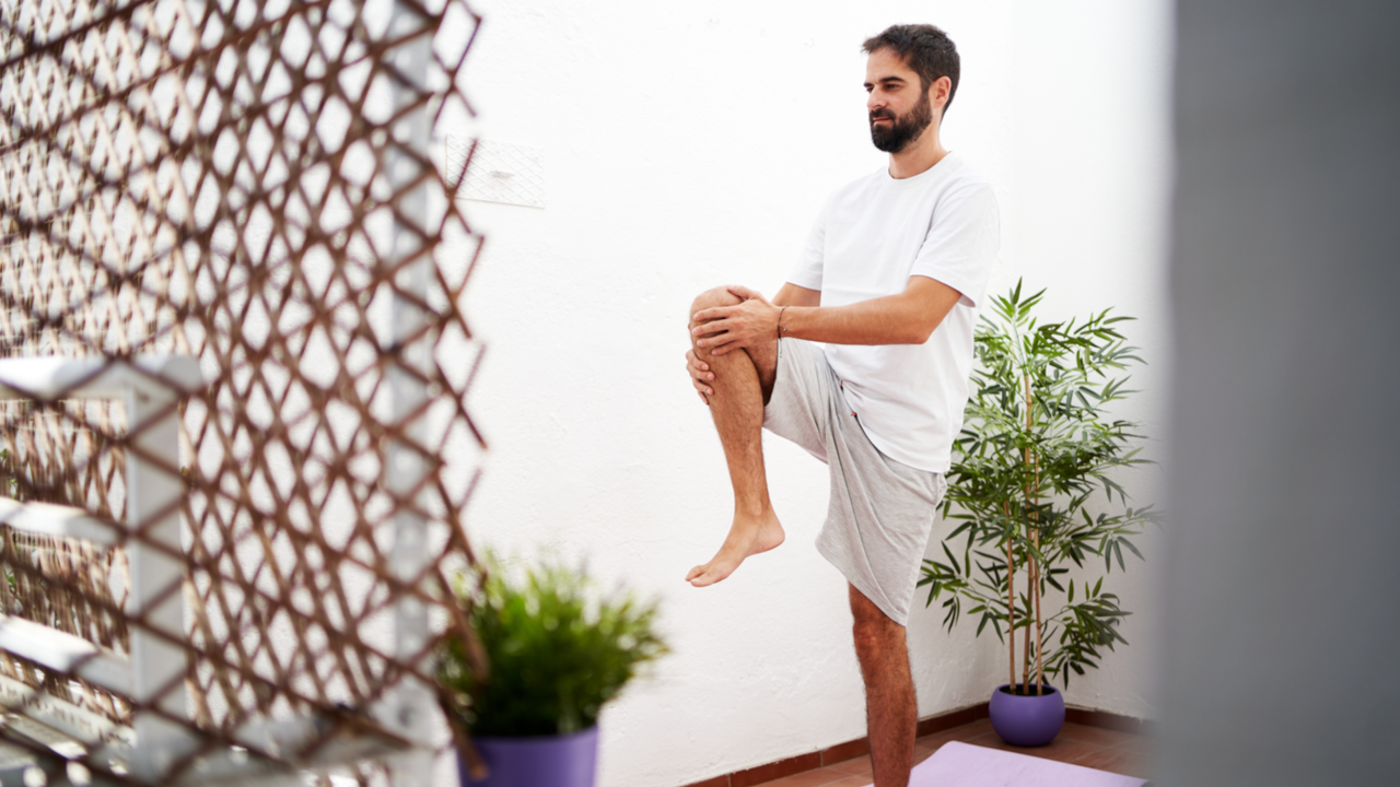 Man performing knee holds in his garden