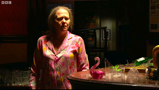 Linda stares at the glass flamingo