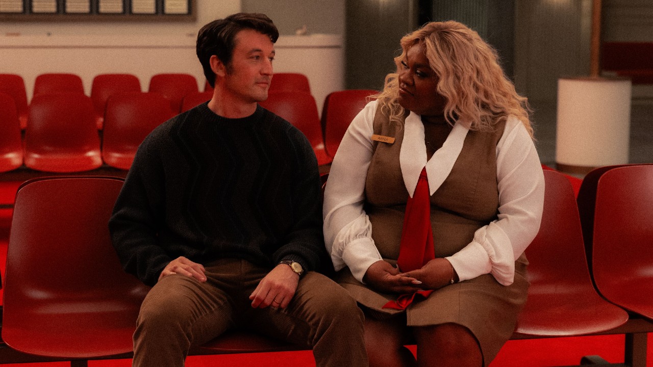 From left to right: Miles Teller sitting in a chair and looking at Da'Vine Joy Randolph, who is sitting right next to him.