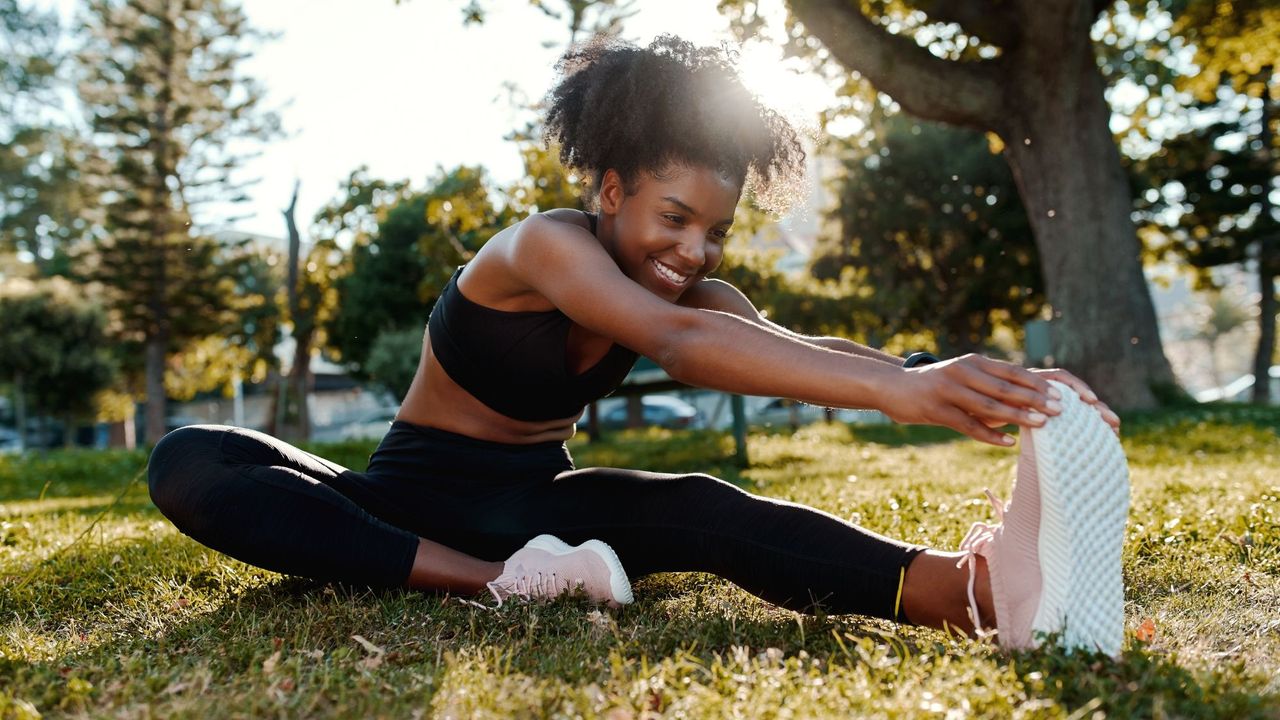 Running tips: A woman stretching her legs after a run