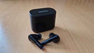 Denon Noise Cancelling Earbuds pictured next to their case