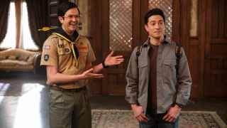 From left to right: Pete putting his hands up and out to show off Kyle, who is standing next to him with his thumbs in his pockets.