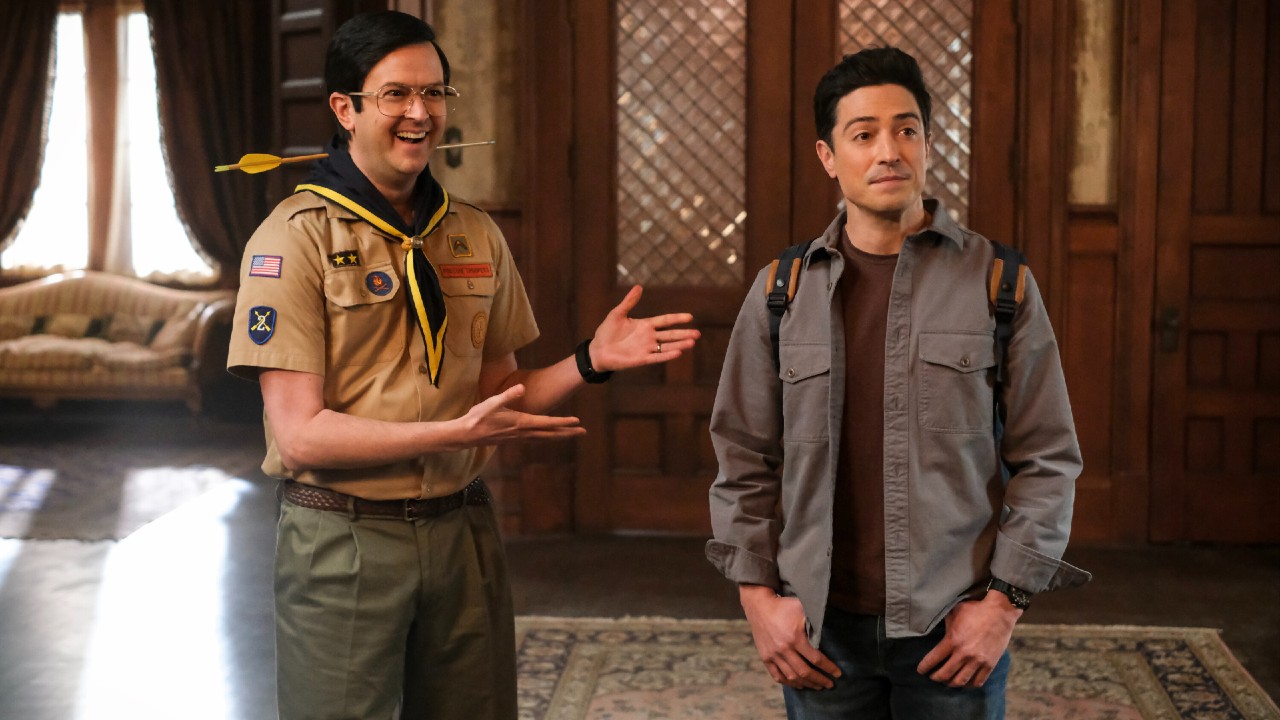 From left to right: Pete putting his hands up and out to show off Kyle, who is standing next to him with his thumbs in his pockets.