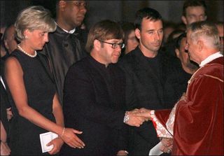 Archpriest Magio (R) shakes hands with British rock star Elton John standing next to Princess Diana