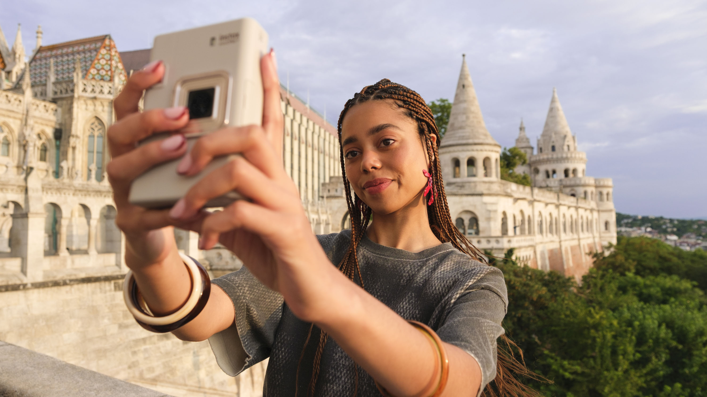 Woman taking a selfie with the Fujifilm Instax mini LiPlay+ hybrid instant camera