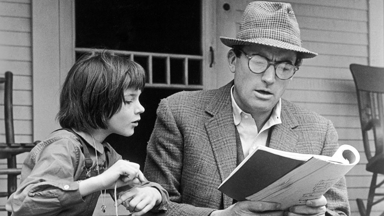 Man reading to little girl on porch