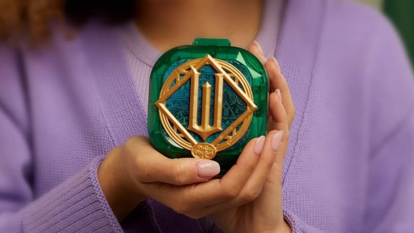 Promotional image for the Mattel Polly Pocket Wicked Compact displaying a child showing the golden &#039;W&#039; on its exterior.