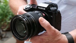 Fujifilm X-H2 with a lens held in hands