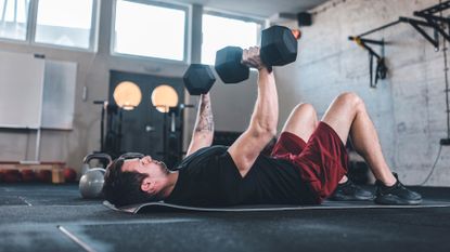 Man completing chest presses with two dumbbells