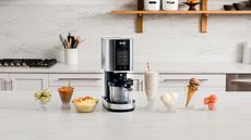 The Ninja Creami on a countertop surrounded by ice cream