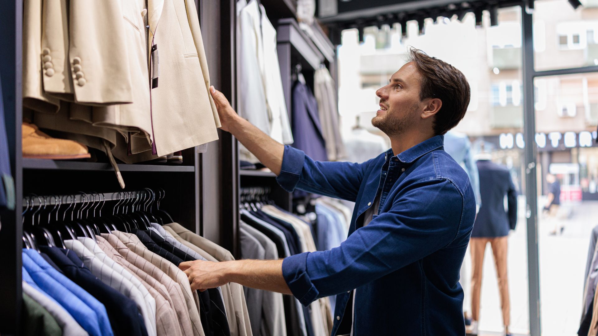 an image of a man at clothing store looking for a suit