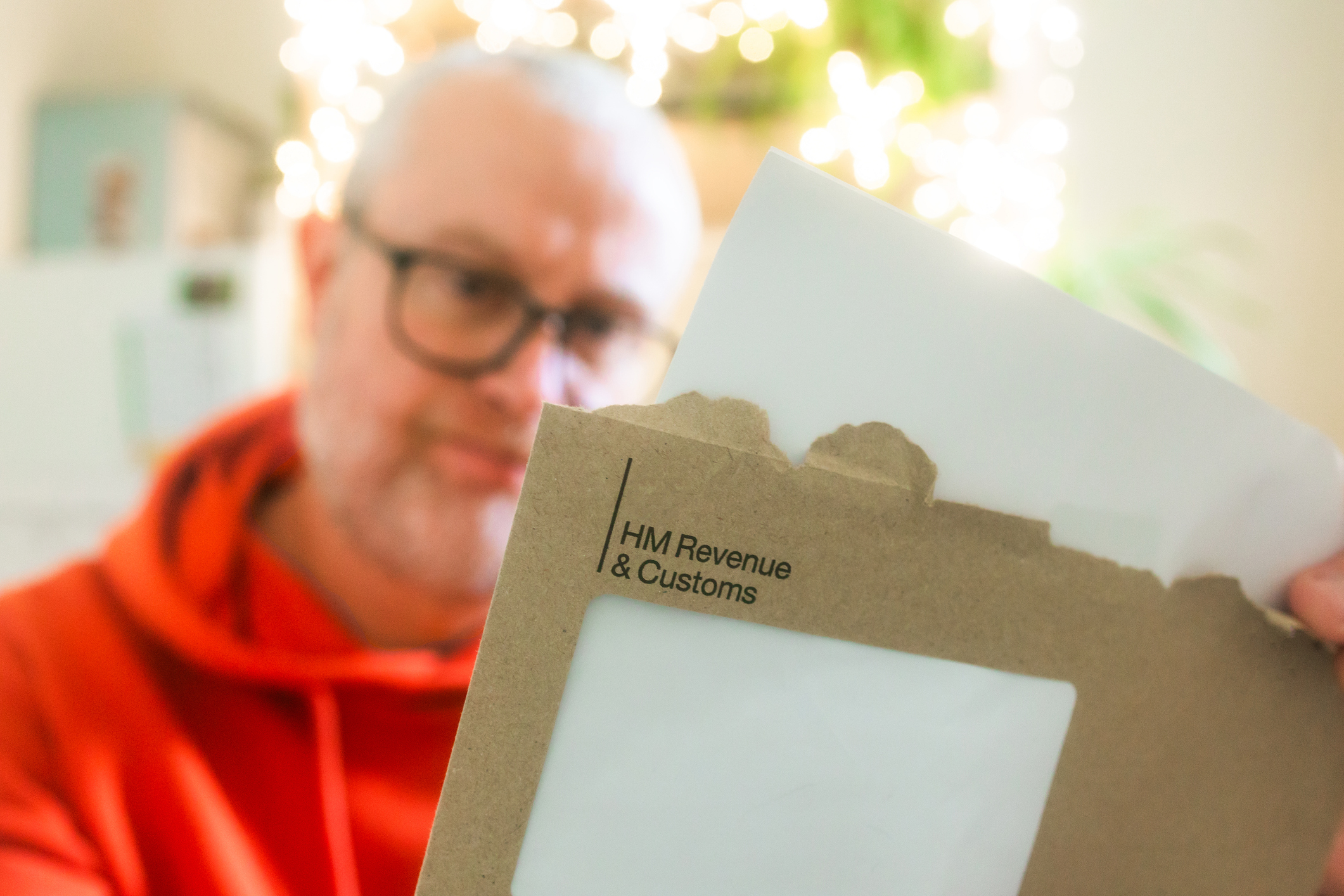 Man opening a letter about tax from HMRC